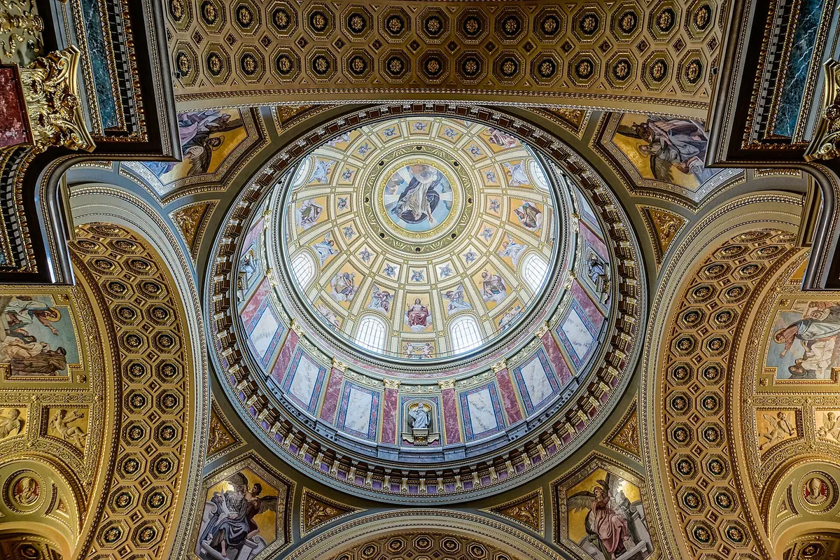 The central dome of St Stephen's Basilica seen from below, with a ring of windows, mosaic panels and gilded coffering on the pendentives