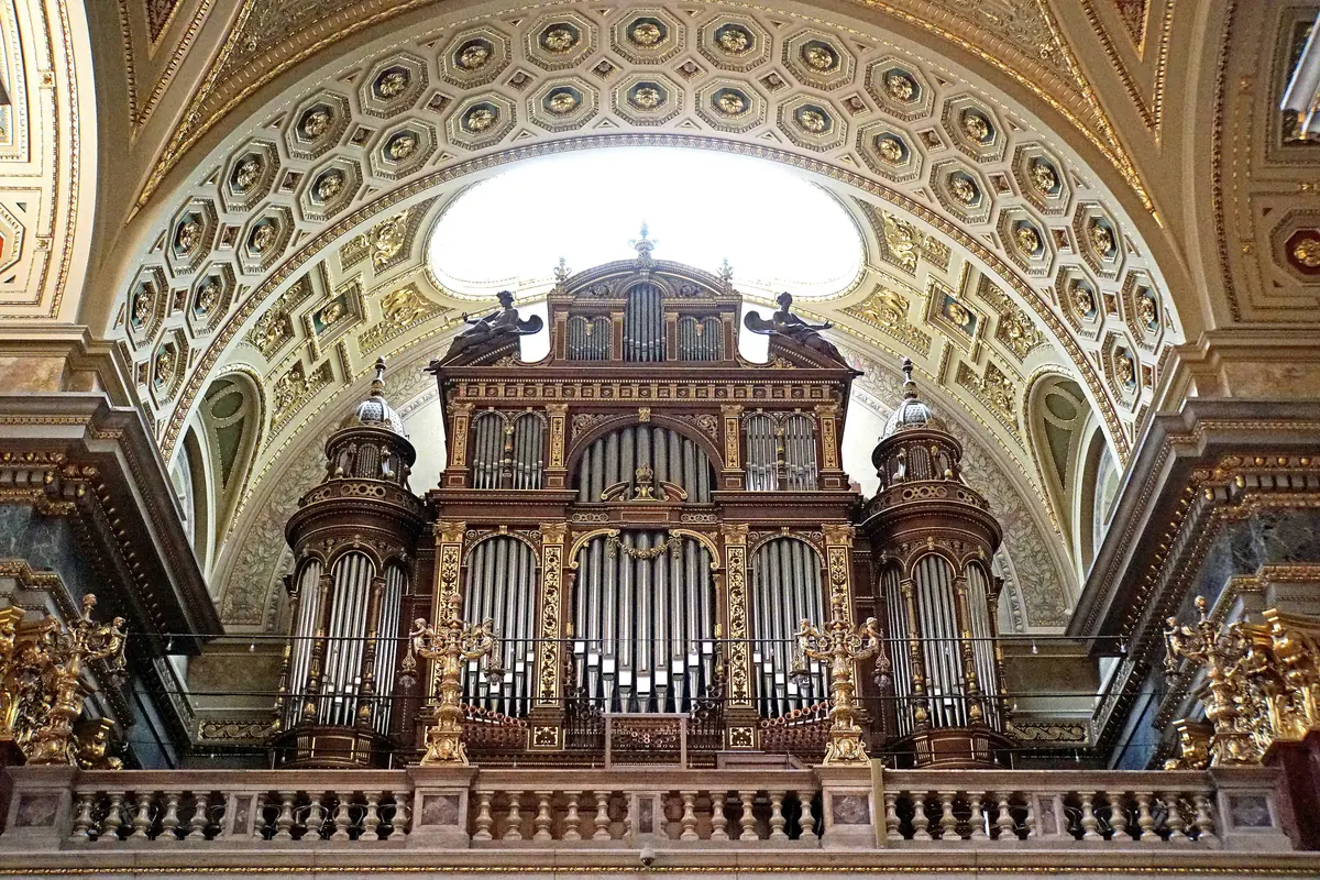 The Angster organ of St Stephen's Basilica: a dark wood case with gilded ornament and silver pipes, set under a coffered arch